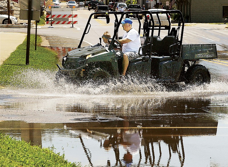 A man and a young child splash through the floodwaters covering Main Street near state Route 3 Thursday, in Grafton, Illinois.  Grafton sits on the confluence of the Mississippi and Illinois rivers which are expected to crest in Grafton this weekend.