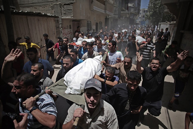 Palestinian mourners chant slogans as they carry the bodies of eight members of the Al Haj family, who were killed in an Israeli missile strike early morning, during their funeral in Khan Younis refugee camp, southern Gaza Strip Thursday.