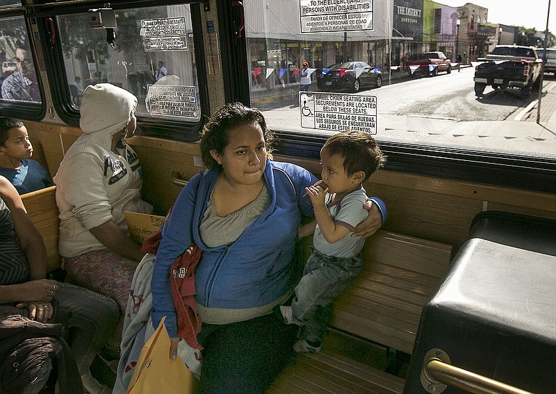 In this photo taken July 4, 2014, Marta Beltran, 19, of El Salvador, holds her 18-month-old son, Lenny, as they ride a city shuttle bus from the McAllen city bus station to the Sacred Heart Catholic Church Shelter in McAllen, Texas. About 90 Hondurans a day cross illegally from Mexico into the U.S. at the Rio Grande near McAllen, according to the Honduran Consulate, and the families are then brought to Central Station in McAllen and each is released on their own recognizance.