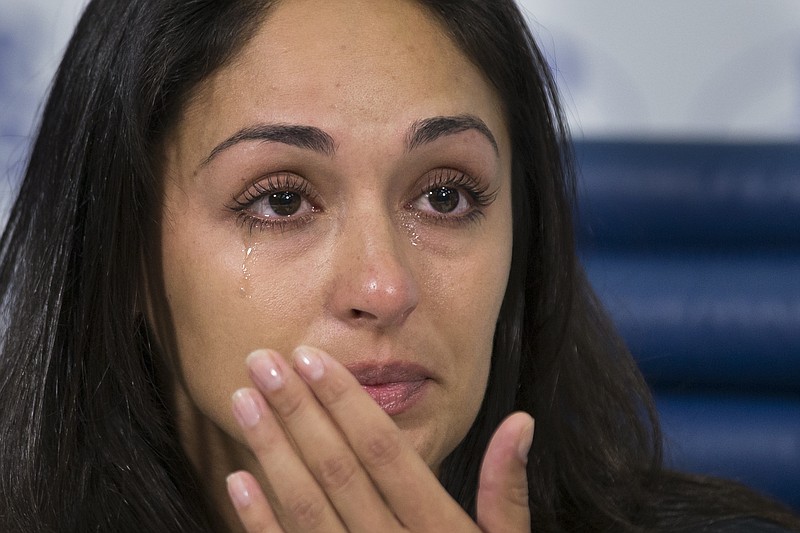 Anna Otisko, the girlfriend of Roman Seleznev, a Russian man who was arrested on bank fraud and other charges earlier this week in the United States, cries as she listens to a question during a news conference in Moscow, Russia, Friday, July 11, 2014. Family members of a Russian man charged with hacking in the United States insist he is innocent and fear incarceration will kill him.