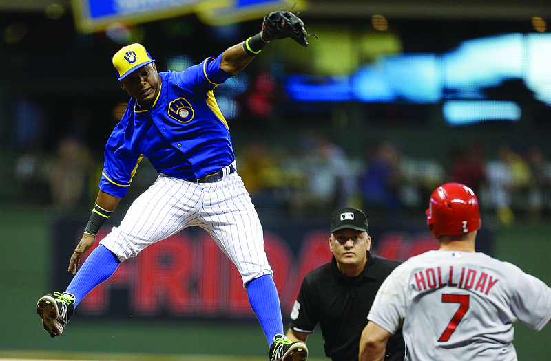 Brewers shortstop Jean Segura leaps, but can't come up with a high relay throw as Matt Holliday of the Cardinals reaches on a double in the fourth inning of Friday's game in Milwaukee.