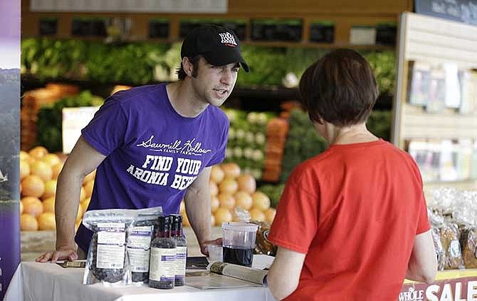 Andrew Pittz of the Sawmill Hollow aronia berry farm offers samples and sells aronia berry products at Whole Foods Market in Omaha, Neb., Friday, April 25, 2014. A few years ago, few people had ever heard of the Aronia berry, a pretty, but tart fruit. Now, the berry has set its sights on becoming the next "superfood" and is in hundreds of products worldwide. 