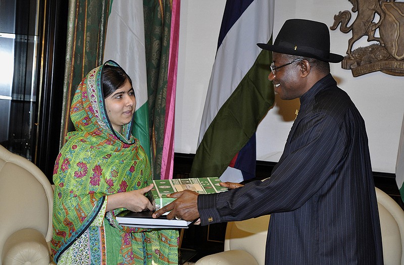 Pakistani activist Malala Yousafzai, left, receives a gift from Nigerian President Goodluck Jonathan.