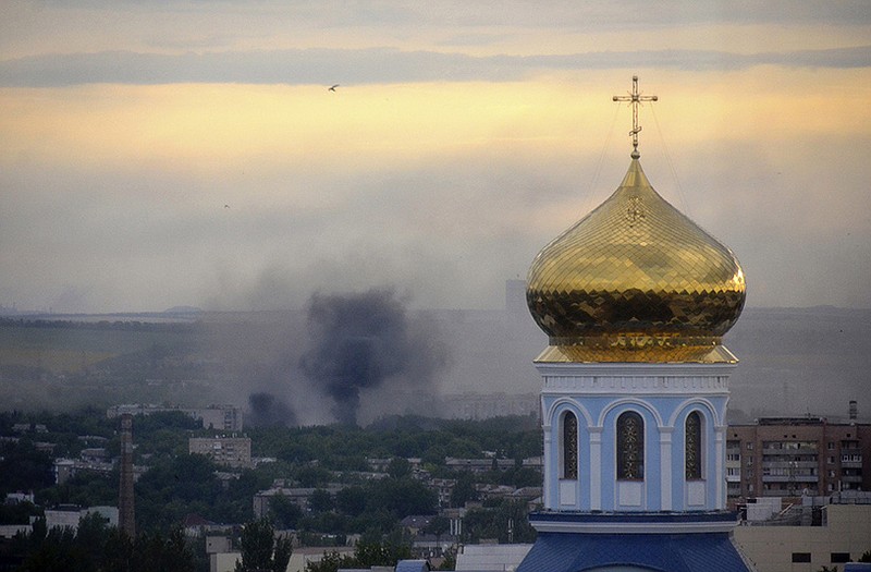 Black smoke billows following a mortar attack during fighting between Ukrainian government troops and pro-Russian fighters in Luhansk, Ukraine.  The United States is considering imposing unilateral sanctions on Russia over its threatening moves in Ukraine.