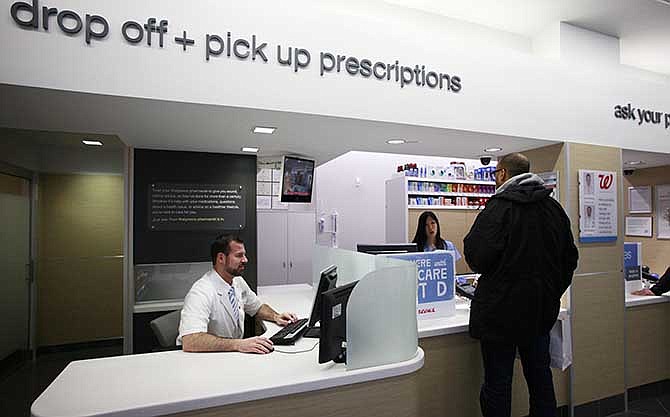  In this May 15, 2013, file photo, a pharmacist works at his desk located next to the prescription pick up counter in New York.