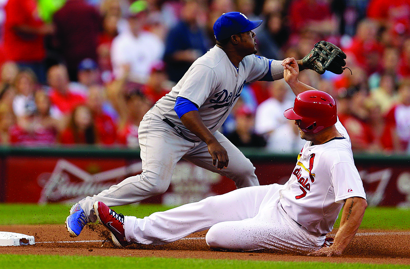 Matt Holliday of the Cardinals is safe at third as Dodgers third baseman Juan Uribe looks for the throw during the first inning of Friday night's game in St. Louis. 