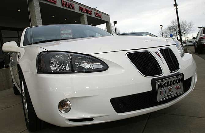 This Feb. 18, 2007, file photo shows an unsold 2006 Grand Prix sedan sitting outside a General Motors dealership in Boulder, Colo. 