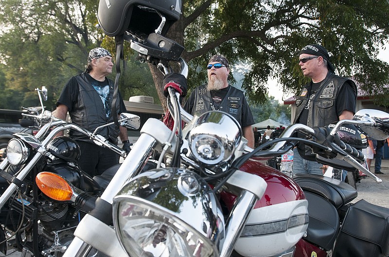 (From left) Ron Aungerer and Shawn Mullins, both of Fulton, and Joe Cox of Jefferson City talk near their motorcycles Friday at the ninth annual Frogs and Hogs Festival in Mokane.
