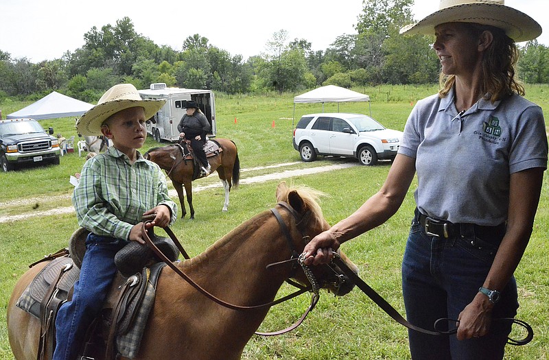 Levi Lackman, 4, St. Thomas, waits with his mother, Linda, for the start of an event Sunday at the Cole County 4-H and FFA Horse Show. 