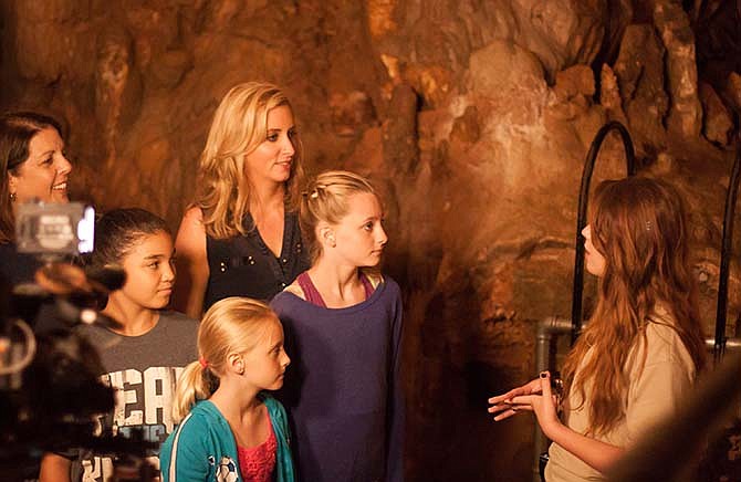 Colleen Kelly, host of National Public Television show "Family Travel with Colleen Kelly," listens to a Bridal Cave tour guide explain about the attractions' unique formations Tuesday, along with local guests and her two daughters, Dunovan Kate, 12, and Shea Grace, 9. The three-day filming project highlighted Lake of the Ozarks for an episode set to premier next spring. (Evan Lampe/Lake of the Ozarks Convention & Visitor Bureau) 
