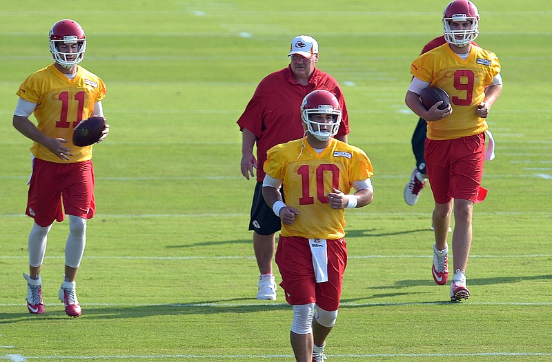 Chiefs quarterbacks Alex Smith (11), Chase Daniel (10) and Tyler Bray (9) take off down the field with head coach Andy Reid during drills Monday in St. Joseph.