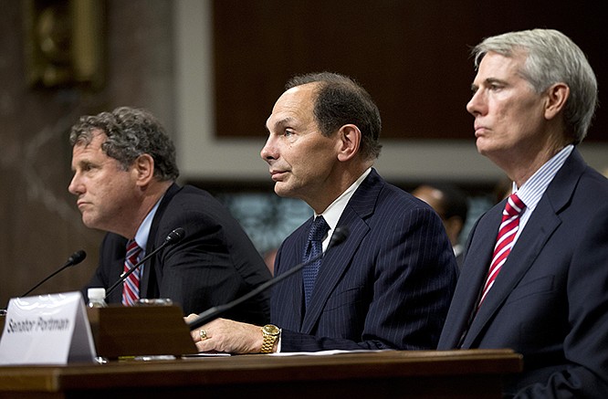 Veterans Affairs Secretary nominee Robert McDonald, flanked by Sens. Sherrod Brown, D-Ohio, left, and Rob Portman, R-Ohio, right, listens during a Senate Veterans' Affairs Committee hearings.