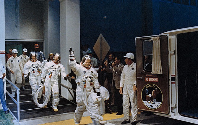 In this July 16, 1969 file photo, Neil Armstrong, waving in front, heads for the van that will take the Apollo 11 crew to the rocket for launch to the moon at Kennedy Space Center in Merritt Island, Fla. NASA renamed the historic building at Florida's Kennedy Space Center on Monday, July 21, 2014, in honor of Armstrong, the first man to step foot on the moon 45 years ago.