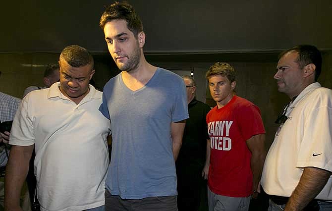 Daniel Petryszyn, second left, and Bryan Caputo, third left, are escorted to their arraignment proceedings in New York state Supreme Court, Wednesday, July 23, 2014. They are two of six people who were indicted Wednesday in an international ring that took over more than 1,600 StubHub users' accounts and fraudulently bought tickets to such prime events as Jay-Z and Elton John concerts and Broadway shows like "The Book of Mormon," the Manhattan district attorney said Wednesday.