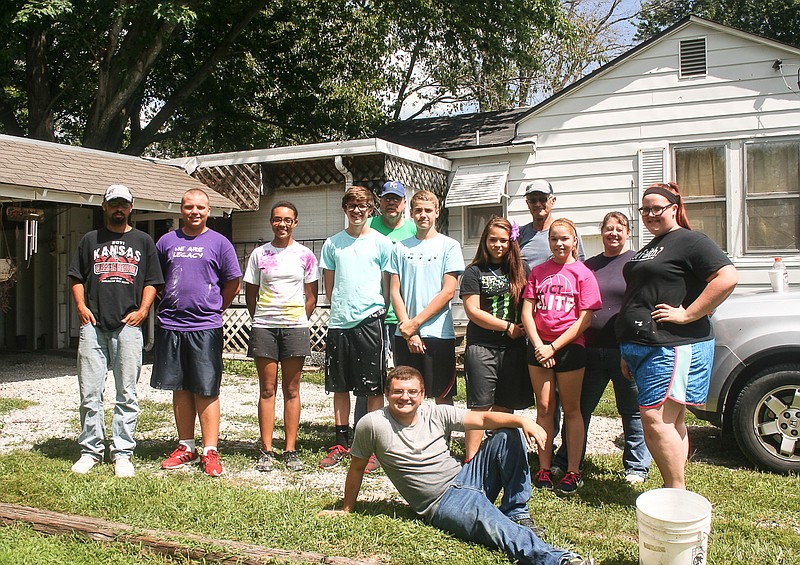 3MT missionaries working on a house on South Street, Jamestown, take a break Thursday. The group cleaned the gutters, did some repair work, painted and trimmed trees at the Jamestown residence.
