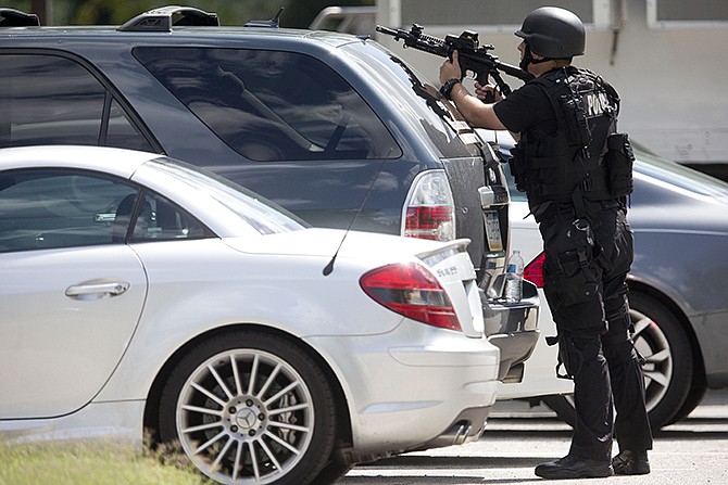 An officer points his weapon near the scene of a shooting Thursday at Mercy Fitzgerald Hospital in Darby, Pennsylvania. Police in suburban Philadelphia are investigating a shooting at the hospital campus and say they have reports people have been injured and a suspect is in custody. 