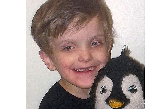 Connor Brotherton, 7 years old, holds his "Happy" doll from the movie "Happy Feet.' Brotherton calls the penguin his best friend.