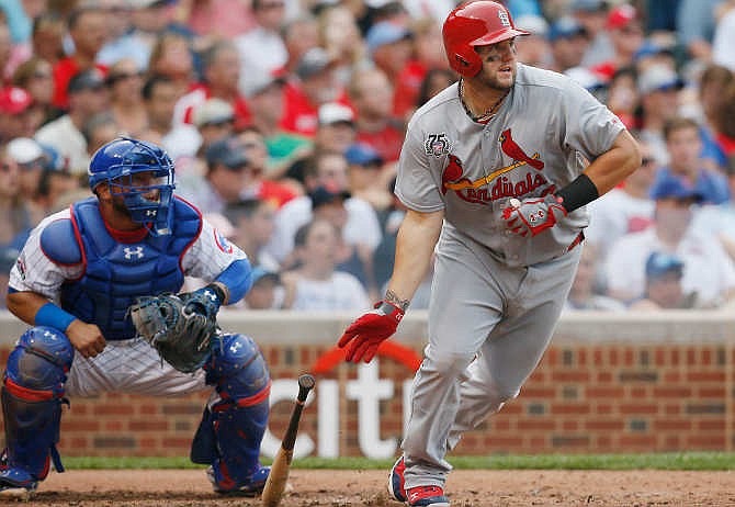 St. Louis Cardinals' Matt Adams watches his two-run triple against the Chicago Cubs during the seventh inning of a baseball game on Saturday, July 26, 2014, in Chicago. 