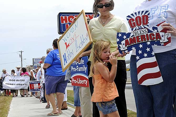 Taos resident Mary Hoffmeyer asks her granddaughter Sawyer Hoffmeyer if she's doing OK in the heat as they
participate in a pro-life rally along Missouri Boulevard in front of Hobby Lobby in Jefferson City on Saturday. The rally was organized as a celebration for both Hobby Lobby's recent victory in the Supreme Court and Thursday's acquittal of Kathy Forck, campaign director of 40 Days for Life's Columbia chapter.