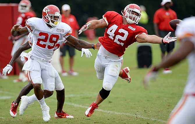 Kansas City Chiefs full back Anthony Sherman (42) attempts to catch a pass under pressure from safety Eric Berry (29), during an NFL football training camp Saturday, July 26, 2014, in St. Joseph, Mo.