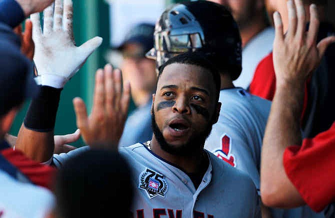 Cleveland Indians' Carlos Santana is congratulated in the dugout after hitting a two-run home run in the ninth inning of a baseball game against the Kansas City Royals at Kauffman Stadium in Kansas City, Mo., Sunday, July 27, 2014. The Indians won 10-3. 