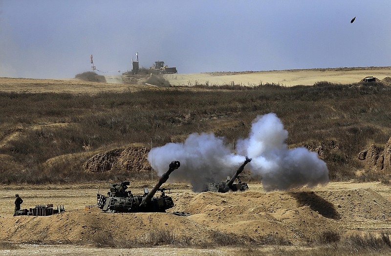An Israeli tank fires towards Gaza, near the Israeli-Gaza border on Sunday.