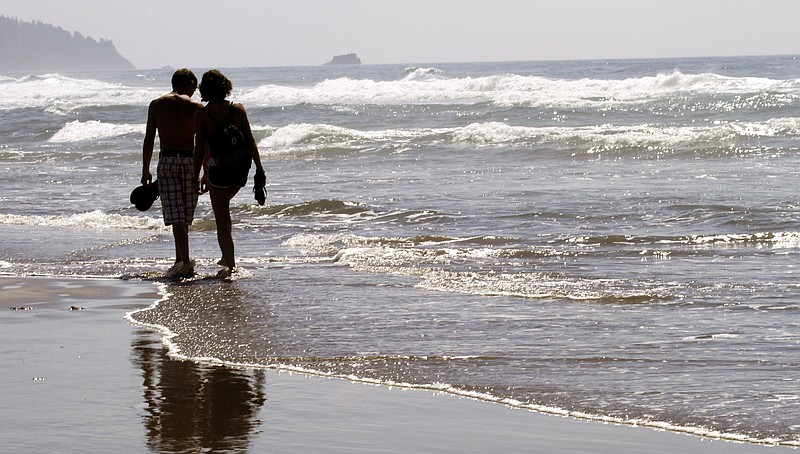 In this Aug. 26, 2010 file photo, a couple walks through the surf together in Cannon Beach, Ore. OKCupid on Monday, July 28, 2014 became the latest company to admit that it has manipulated customer data to see how users of its dating service would react to one another.