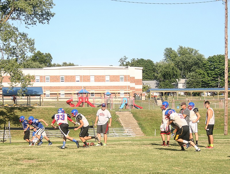 California High School Assistant Football Coach Rick Edwards, center, and head coach Marty Albertson, right, work with the Pintos Thursday at the CHS Football Camp for grades 9-12 at Riley Field. 