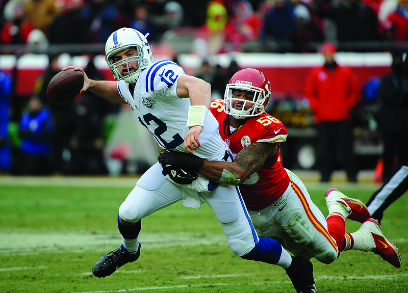 In this Dec. 22, 2013, file photo, Colts quarterback Andrew Luck tries to get rid of the ball while being tackled by Chiefs inside linebacker Derrick Johnson during the first half of a game at Arrowhead Stadium.