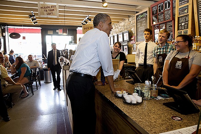 President Barack Obama talks to staff at Parkville Coffee during a surprise stop along Main Street in Parkville, Missouri Wednesday, before leaving Missouri to return to Washington after speaking about the economy. 