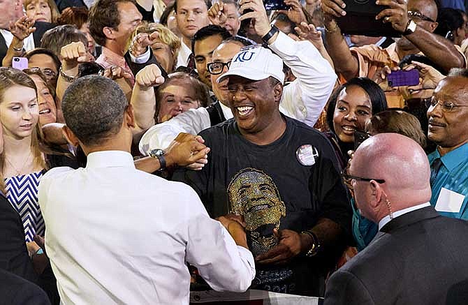 President Barack Obama greets Grayling Taylor of Kansas City, Mo., wearing a Barack Obama t-shirt, after the president spoke about the economy, Wednesday, July 30, 2014, at the Uptown Theater in Kansas City, Mo.