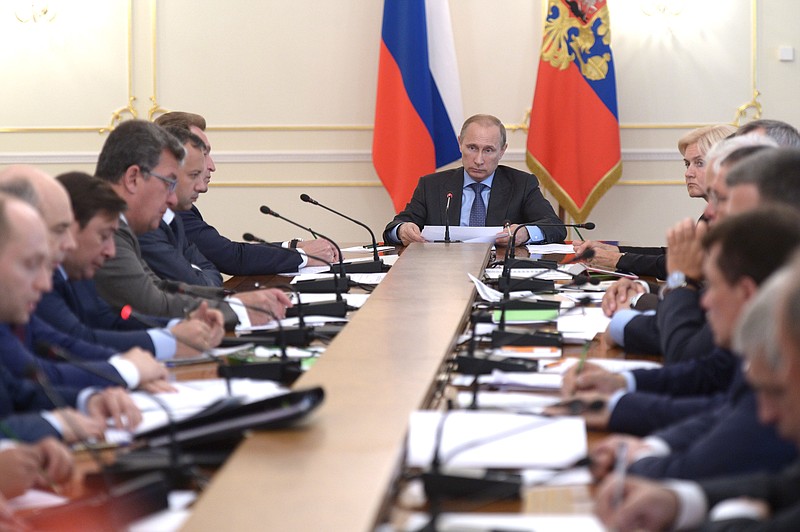 Russian President Vladimir Putin, background center, heads the Cabinet meeting in the Novo-Ogaryovo residence, outside Moscow, Wednesday. The meeting focused on measures to encourage Russian companies to pull their assets back from offshore. The United States and the European Union on Tuesday announced a raft of new sanctions against Russian companies and banks over Moscow's support for separatists in Ukraine. 