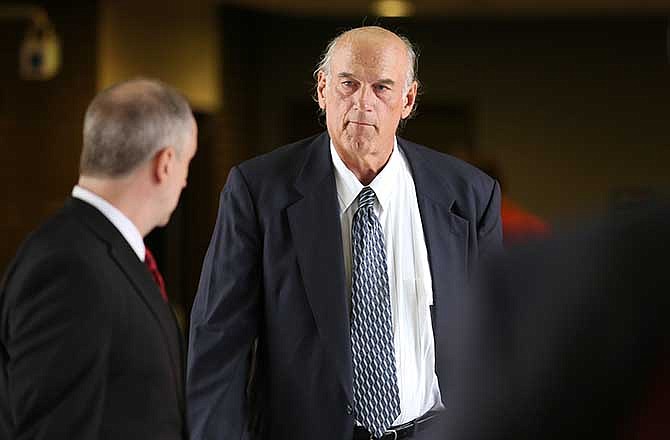 Former Minnesota Gov. Jesse Ventura, right, makes his way back into Warren E. Burger Federal Building during trial of a defamation lawsuit, Tuesday, July 8, 2014 in St. Paul, Minn. The jury later found in Ventura's favor in his suit against the Chris Kyle estate, claiming that Kyle's account of a bar fight in a book he wrote was false. (AP Photo/The Star Tribune, Elizabeth Flores)