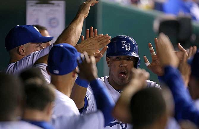 Kansas City Royals catcher Salvador Perez (13) celebrates with teammates after scoring on an Alex Gordon double in the sixth inning during a baseball game against the Minnesota Twins Wednesday, July 30, 2014, in Kansas City, Mo.