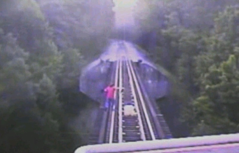 In this frame grab from surveillance video provided by the Indiana Rail Road via WRTV, two women run down a railroad track ahead of a freight train coming toward them, July 10, in Monroe County in Indiana. The women survived the incident, but authorities are reviewing the video for potential criminal charges.