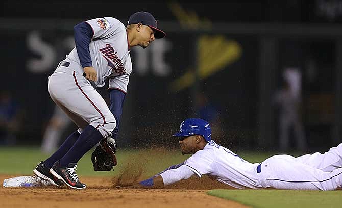 Kansas City Royals' Jarrod Dyson slides into second for a steal past the tag of Minnesota Twins second baseman Eduardo Escobar in the seventh inning during a baseball game Thursday, July 31, 2014, in Kansas City, Mo.