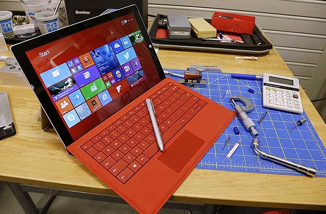 This photo taken July 3, 2014 shows a Microsoft Surface Pro 3 tablet computer and a pen to precisely write on its touchscreen, posed for a photo on a bench in a Microsoft design lab in Redmond, Wash. Back-to-school shoppers in Missouri will pay less in sales tax on computers and other school-related supplies over the next weekend, thanks to the state's annual sales tax holiday.