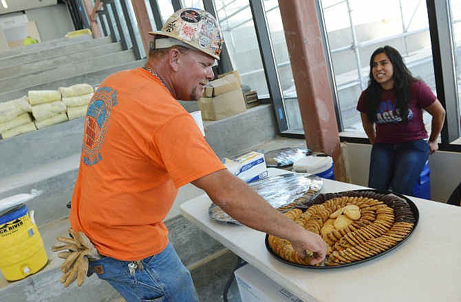 Jeff Vollmer, with Weaver Steel, takes a cookie from incoming Joplin High senior Maricela Santillan at the construction site of the new Joplin High School in Joplin, Mo., on Friday, July 25, 2014. Students offered cookies and lemonaide to workers at the site as a thank you for their work in building the new school. The new building, slated to open in late August, will replace the school lost in the 2011 tornado. (AP Photo/The Joplin Globe, Roger Nomer)