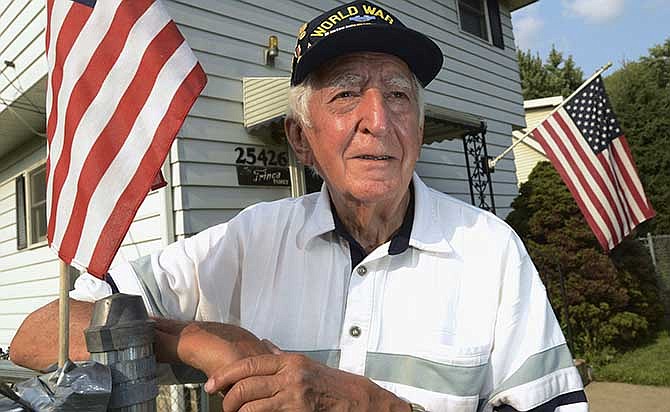 In this Thursday, July 31, 2014 photo, veteran John Trinca stands outside his home in Antioch Township, Ill. Trinca was with U.S. Army Pvt. Thomas Bateman, a soldier he had just met in the Philippines in 1945 in World War II when Bateman was killed from Japanese machine gun fire. The Purple Heart that Bateman paid for with his life became lost and was eventually found in the 1950s by Tom McAvoy as a kid in Chicago. Trinca will be on hand Sunday, Aug. 3, 2014, when the Purple Heart will be returned to Bateman's family in Grayslake, Ill. (AP Photo/Daily Herald, Paul Valade)