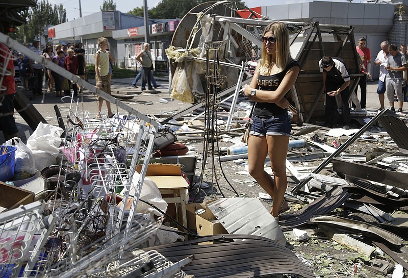 Local residents inspect the damage after night shelling on a local market in Donetsk, eastern Ukraine, Wednesday. Air strikes and artillery fire between pro-Russian separatists and Ukrainian troops in the eastern city of Donetsk have brought the violence closer than ever to the city center, as Kiev's forces move in on the rebel stronghold.