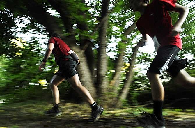 Guy Krause, left, and his son Benjamin Krause make their final kick through the woods as they begin their climb to the finish line while competing in the 7.5-mile run during the Jefferson City Rotaract Club's second annual "Kicks In The Sticks" Trail Run at Binder Park last year.