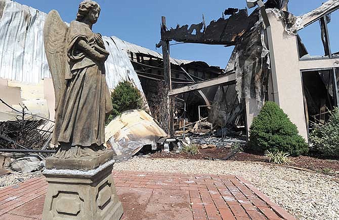 A statue stands next to the still-smoldering Carl Junction, Mo. United Methodist Church on Thursday morning, Aug. 7, 2014. The southwest Missouri church that was rebuilt after a 2003 tornado was destroyed again by fire after an apparent lightning strike. (AP Photo/The Joplin Globe, Laurie Sisk)