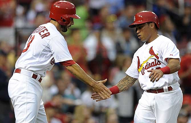 St. Louis Cardinals' Matt Carpenter, left, and Kolten Wong celebrate after scoring on a two-run double by teammate Jhonny Peralta against the Boston Red Sox in the first inning in a baseball game, Thursday, Aug. 7, 2014, at Busch Stadium in St. Louis.