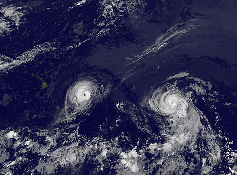 This image provided by NOAA taken Thursday shows Hurricane Iselle, left and Hurricane Julio. Iselle was supposed to weaken as it slowly trudged west across the Pacific. It didn't - and now Hawaii is poised to take its first direct hurricane hit in 22 years. The center of Hurricane Iselle is expected to pass very near or over the Big Island Thursday night and just south of the smaller islands Friday.