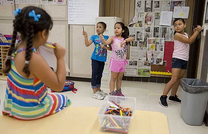 This photo taken July 21, 2014 shows young students in Jane Cornell's summer school class line put to sharpen pencils at Mary D. Lang Kindergarten Center in Kennett Square, Pa.