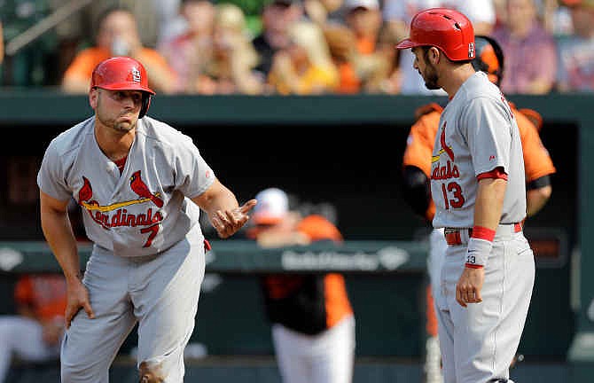 St. Louis Cardinals' Matt Holliday, left, reacts after he was tagged out and teammate Matt Carpenter (13) scored on a double by Jhonny Peralta in the first inning of an interleague baseball game against the Baltimore Orioles, Saturday, Aug. 9, 2014, in Baltimore.