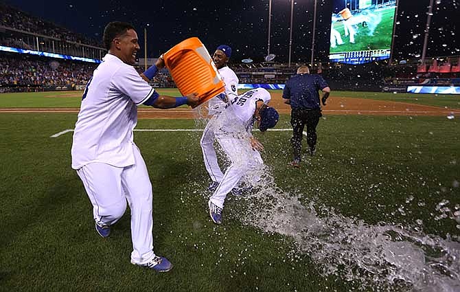 Kansas City Royals starting pitcher James Shields, center, is doused by Salvador Perez, left, and Jarrod Dyson after throwing a complete game shutout against the San Francisco Giants during a baseball game Saturday, Aug. 9, 2014, in Kansas City, Mo. The Royals won 5-0.