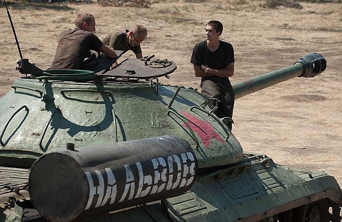 Ukrainian government soldiers sit atop of a tank with the words reading "To Lviv" in Donetsk region, eastern Ukraine, Saturday, Aug. 9, 2014. A top commander of the pro-Russia insurgency in eastern Ukraine said Saturday that Ukrainian forces have seized Krasnyi Luch a key town, leaving the rebel region's largest city of Donetsk surrounded. Lviv is an Ukrainian town