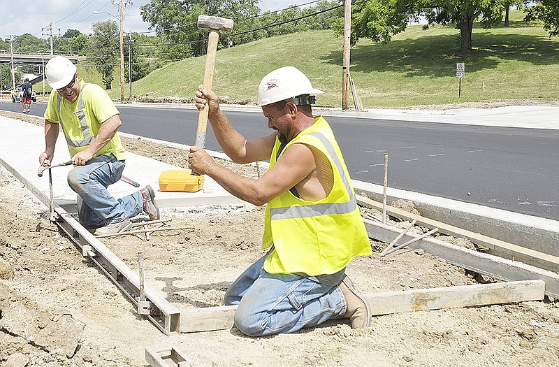 Mike Engelbrecht, near, and Brent Johnson from JC Industries build concrete forms for new sidewalk to be poured along Lafayette Street.