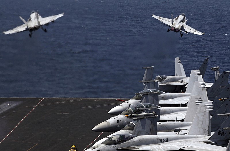 U.S. F/A-18 fighter jets take off for mission in Iraq from the flight deck of the U.S. Navy aircraft carrier USS George H.W. Bush, in the Persian Gulf.